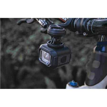 Lampka przednia Moon TITAN MAX zamontowana na kierownicy roweru podczas jazdy w plenerze