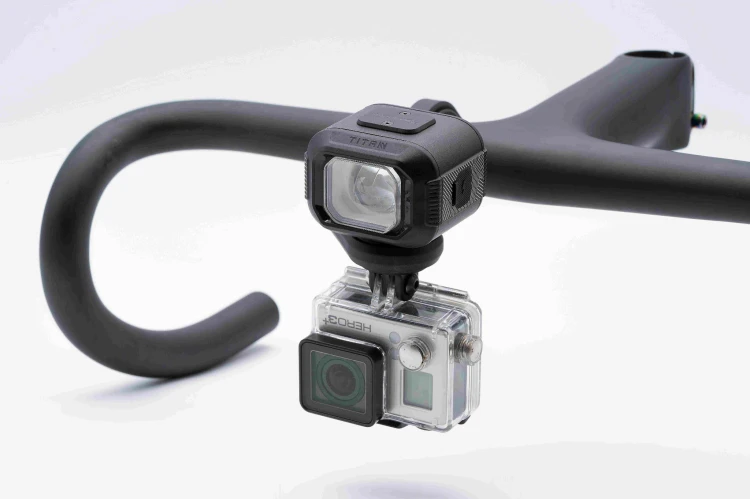 Lampka Moon TITAN MAX zamontowana pod spodem zintegrowanego uchwytu, z kamerą sportową GoPro zamocowaną na tym samym adapterze